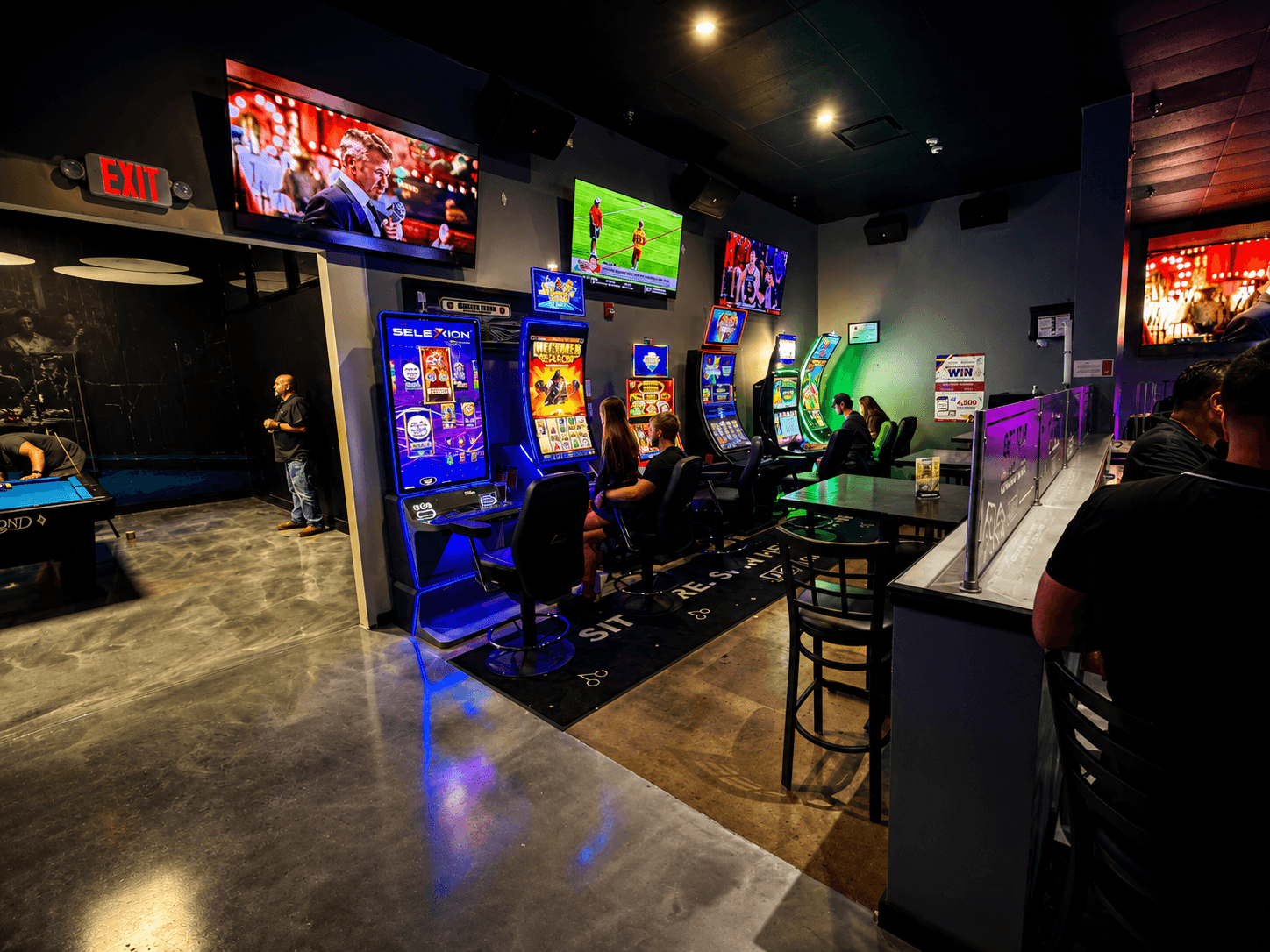 The gaming area — machines lit up with sports playing on the screens above