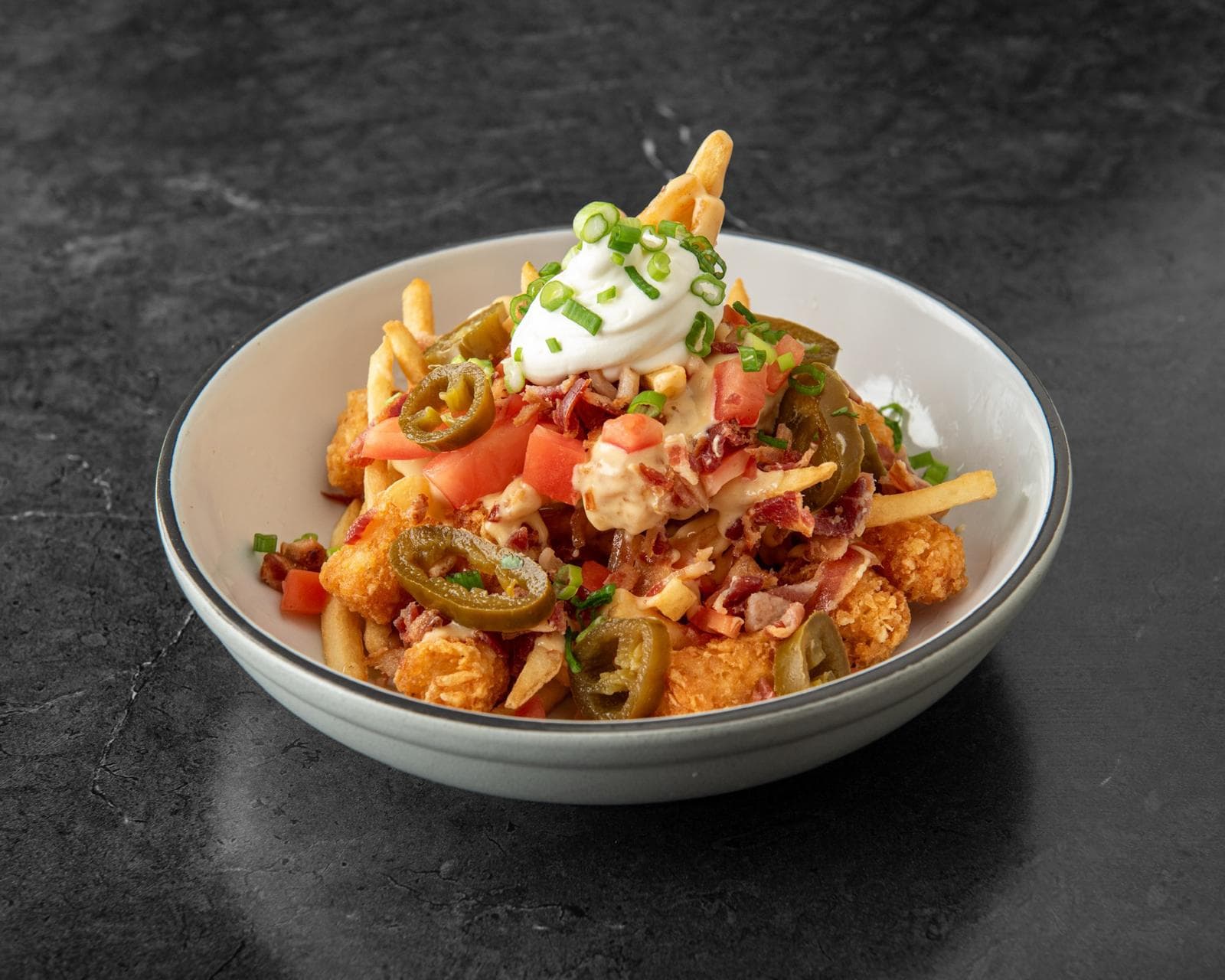 Loaded Frots — fries and tater tots with bacon, cheese, jalapeños and sour cream