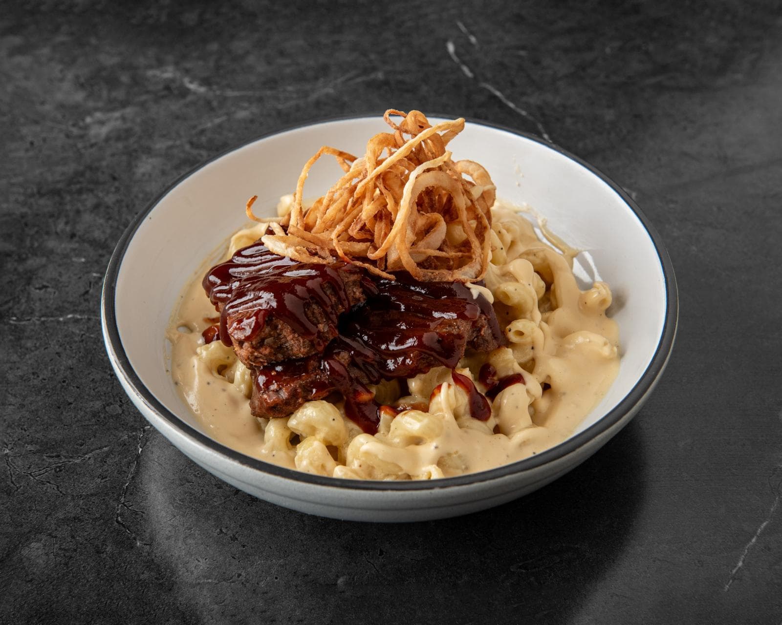 Mac and cheese topped with short rib and crispy onion straws