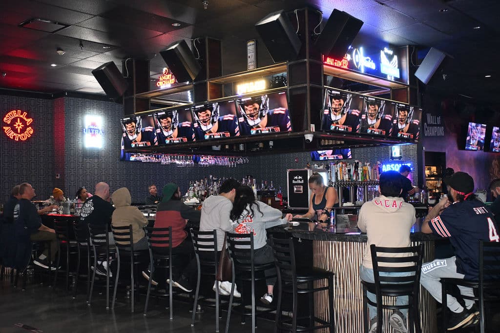 Fans lined up at the bar watching the game