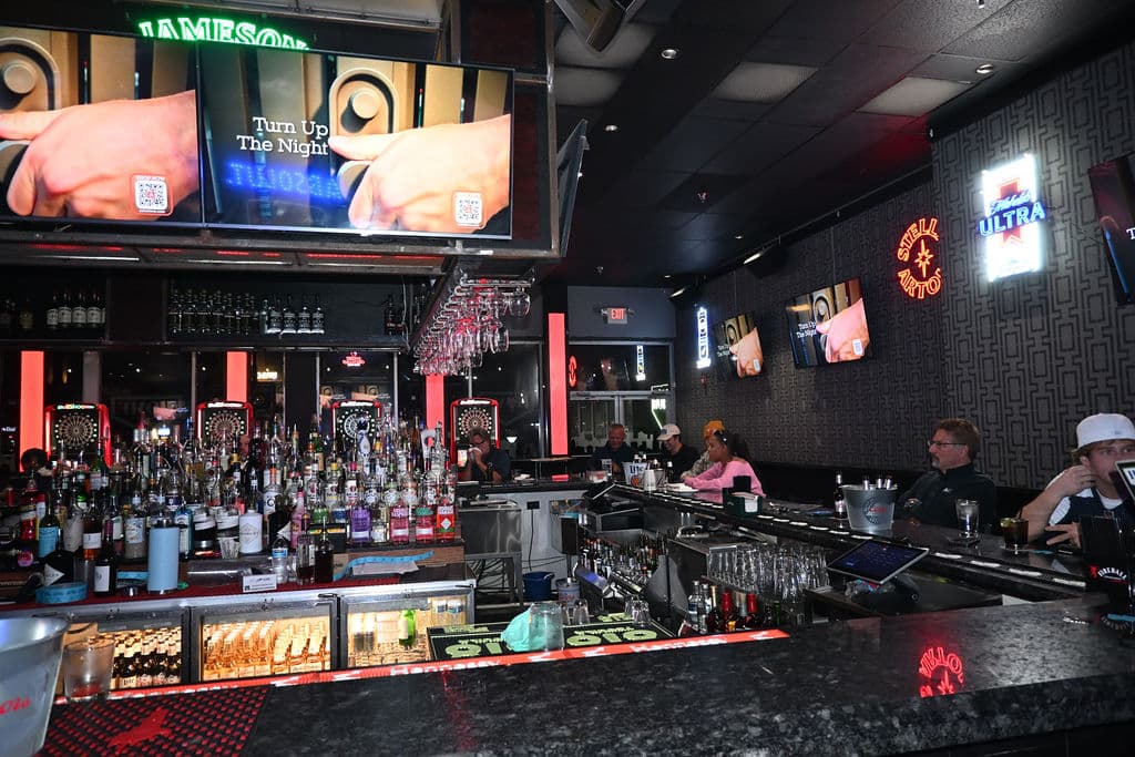 The fully stocked main bar under the screens