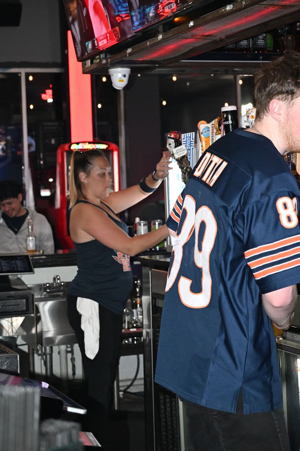 Bartender serving a fan in a Bears jersey